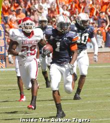 Florida quarterback Tim Tebow crosses the goal line for a touchdown while  being chased by Auburn's David Irons (4), and Will Herring (35) during the  first half of a college football game